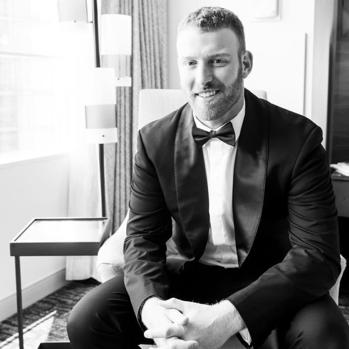 A black and white image of a man wearing a tuxedo