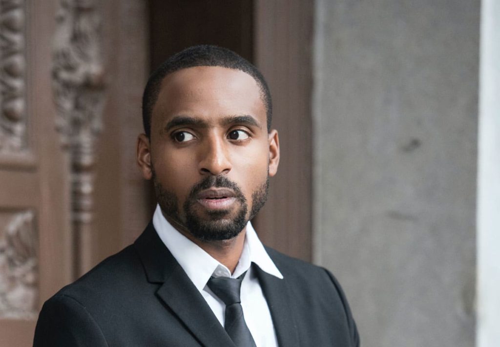 man wearing black notched lapel blazer with clean short beard and mustache